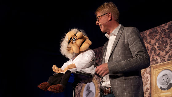 Bauchredner Jörg Jará unterhält sich mit seiner Puppe Professor Jensen auf der Bühne
