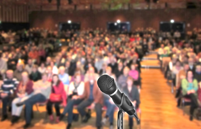 Mikrofon auf Bühne mit Zuschauern
